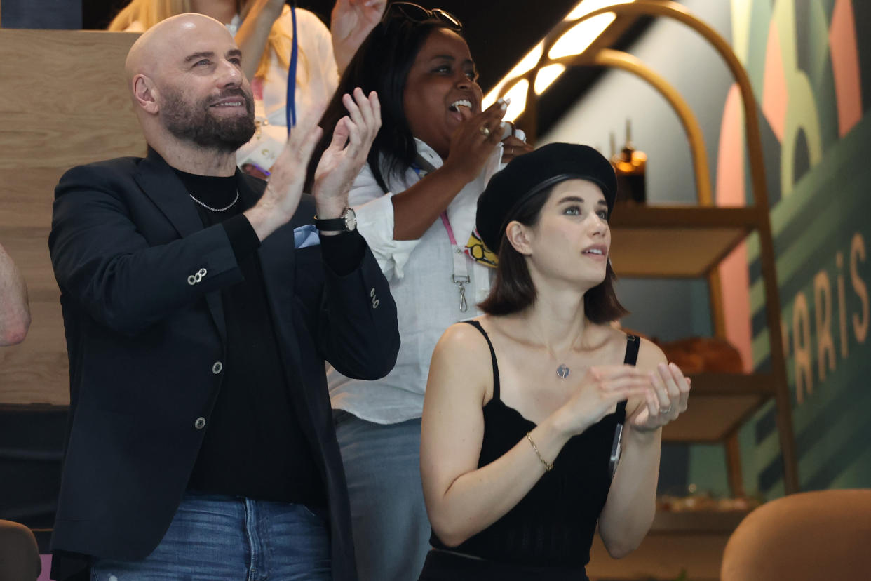 John Travolta and his daughter, Ella, clap  as they watch the Olympics.