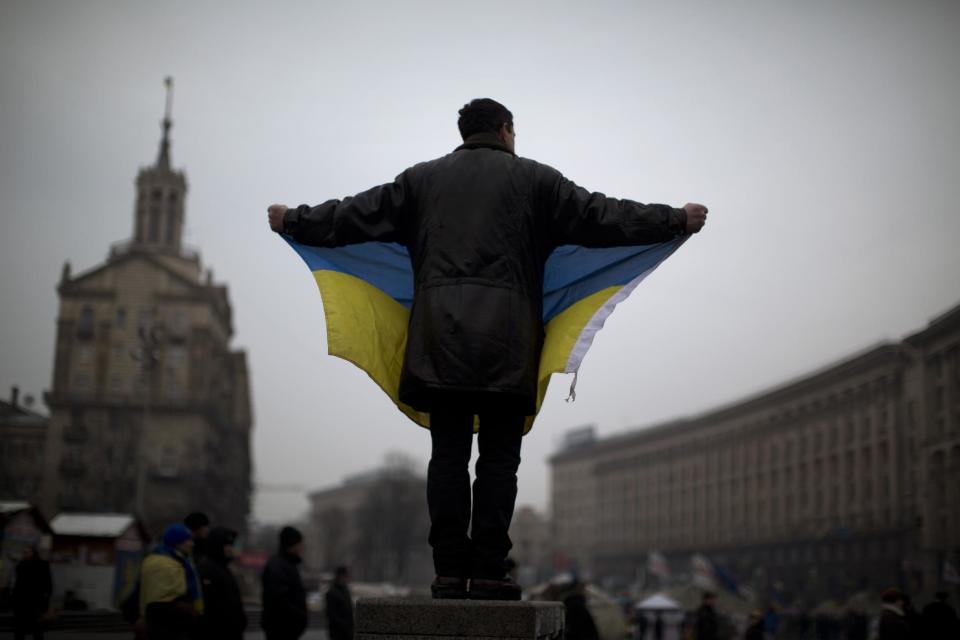 An opposition supporter holds a Ukrainian flag in the center of Kiev's Independence Square, the epicenter of the country's current unrest, Ukraine, Friday, Feb. 7, 2014. Ukrainian protesters lambasted parliament on Thursday for its lack of action, and a senior U.S. diplomat arrived in Kiev to try to help find a resolution to the country's grinding political crisis. Assistant Secretary of State Victoria Nuland met separately with President Viktor Yanukovych and with opposition leaders during her two-day stay in the Ukrainian capital. (AP Photo/Emilio Morenatti)