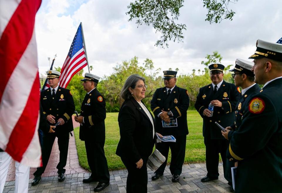 La alcaldesa del Condado Miami-Dade, Daniella Levine Cava, saluda los miembros de los bomberos del condado, antes de la ceremonia de tributo a las víctimas de los ataques terroristas del 11 de septiembre de 2001, en Tropical Park, Miami, el domingo 11 de septiembre de 2022.