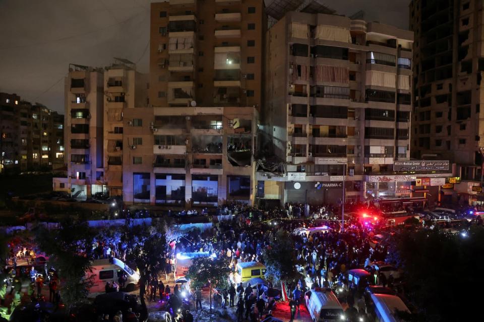 People gather near a damaged site following an explosion, in what security sources say is an Israeli drone strike, at the Beirut suburb of Dahiyeh, Lebanon, on Jan. 2, 2024. 