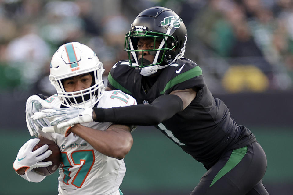 New York Jets cornerback Sauce Gardner (1) attempts to tackled Miami Dolphins wide receiver Jaylen Waddle (17) during the first quarter of an NFL football game, Friday, Nov. 24, 2023, in East Rutherford, N.J. (AP Photo/Adam Hunger)