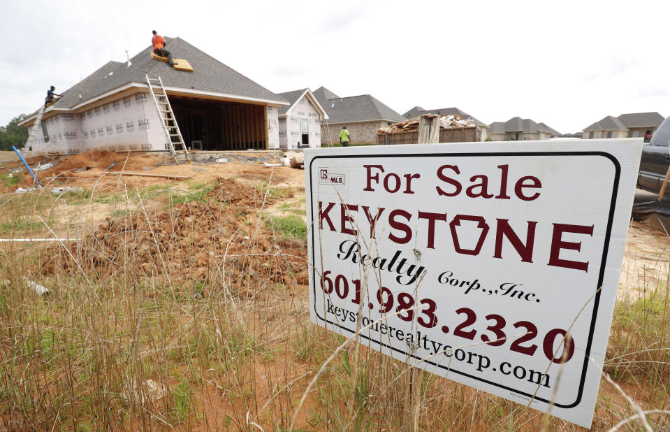 FILE - In this June 19, 2019, file photo workers lay down a roof on a new house in a Brandon, Miss., neighborhood. On Friday, Aug. 23, the Commerce Department reports on sales of new homes in July. (AP Photo/Rogelio V. Solis, File)