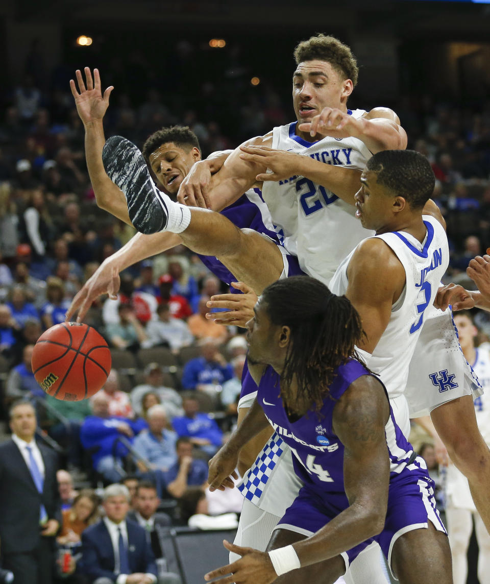 Abilene Christian's Payten Ricks, back left, and Trey Lenox, front, go after a rebound against Kentucky's Reid Travis, center, and Keldon Johnson, right, during the second half of a first-round game in the NCAA men’s college basketball tournament in Jacksonville, Fla., Thursday, March 21, 2019. (AP Photo/Stephen B. Morton)