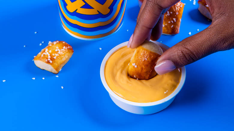 Dipping pretzel nugget in cheese