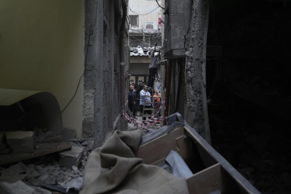 Palestinians inspect a damaged building following an Israeli army raid in the Balata refugee camp near the West Bank town of Nablus Monday, May 22, 2023. A Palestinian militant group said three members were killed in the raid. (AP Photo/Majdi Mohammed)