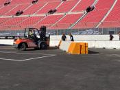 Work is done on a temporary auto racing track inside LA Coliseum ahead of a NASCAR exhibition race in Los Angeles, Friday, Feb. 4, 2022. NASCAR is hitting Los Angeles a week ahead of the Super Bowl, grabbing the spotlight with its wildest idea yet: The Clash, the unofficial season-opening, stock-car version of the Pro Bowl, will run at the iconic coliseum in a made-for-Fox Sports spectacular. (AP Photo/Jenna Fryer)