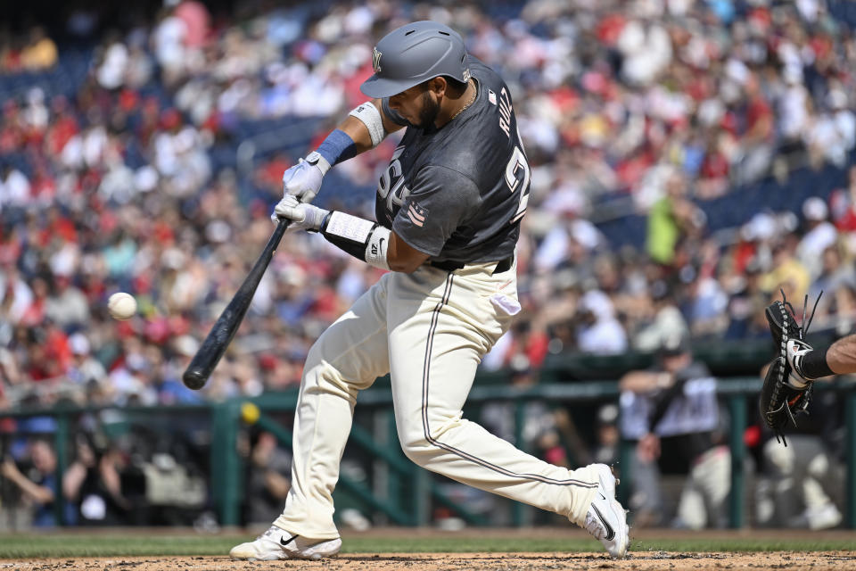 Washington Nationals' Keibert Ruiz hits a sacrifice fly to drive in teammate Luis Garcia Jr. for a run during the second inning of a baseball game against the Seattle Mariners, Saturday, May 25, 2024, in Washington. (AP Photo/John McDonnell)