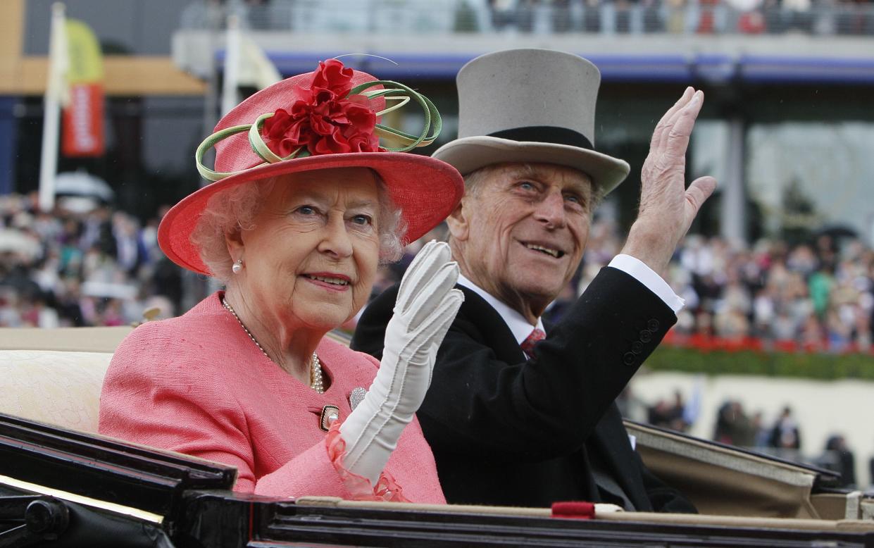 In this Thursday, June, 16, 2011 file photo, Britain's Queen Elizabeth II with Prince Philip arrive by horse drawn carriage in the parade ring at the of the Royal Ascot horse race meeting at Ascot, England. 