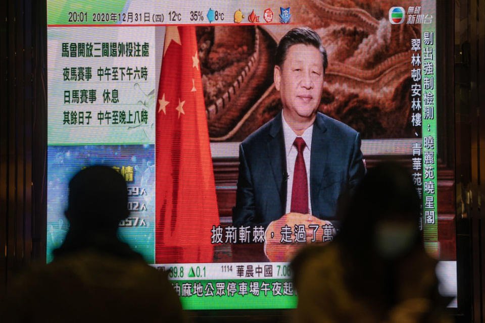 A news report on Chinese President Xi Jinping's New Year's Eve speech is shown on a public screen in Hong Kong, China, on Thursday, Dec. 31, 2020.<span class="copyright">Roy Liu/Bloomberg via Getty Images</span>