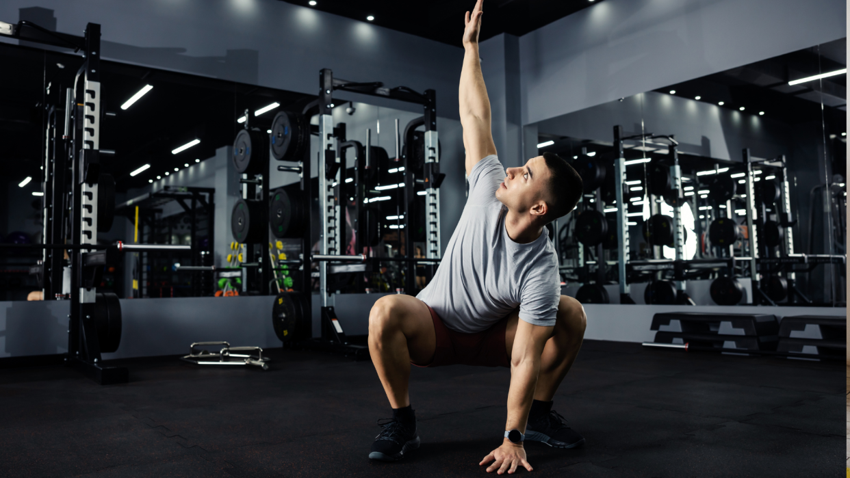  Man doing squat with rotation. 