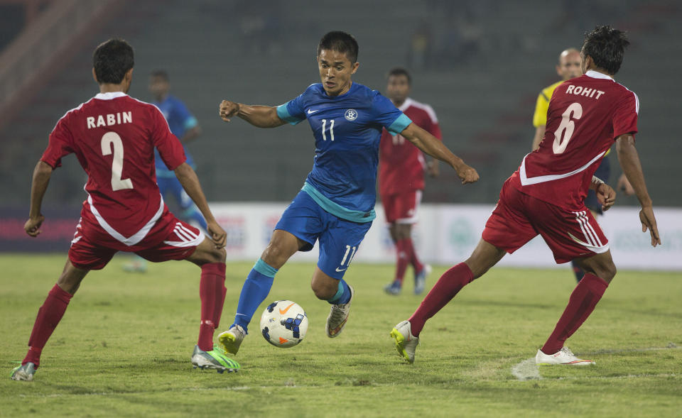 FILE - India's Sunil Chhetri, center, advances with the ball during the team's 2018 World Cup soccer qualifying match against Nepal in Gauhati, India, March 12, 2015. Chhetri scored two goals. Chhetri said this week that after 150 games for India, June’s World Cup qualifier against Kuwait in Kolkata will be his last before retiring. (AP Photo/ Anupam Nath, File)