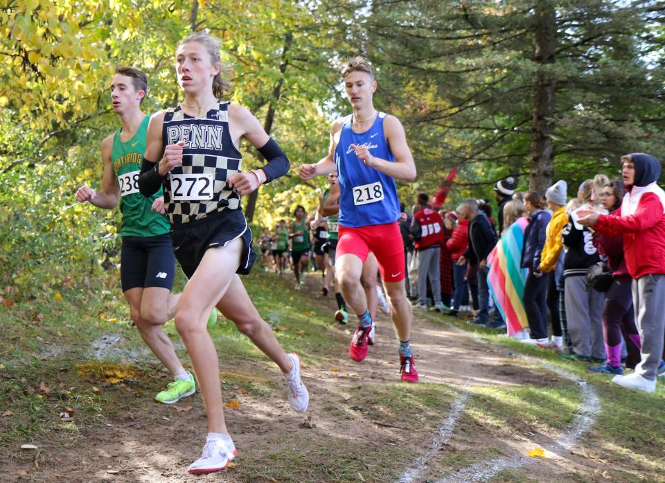 David Gingerich of Northridge (238), Nicholas Probst of Penn (272), and Grayson Wilson of South Bend Adams (218) navigate a turn during Saturday's Cross Country Regional at Ox Bow Park in Goshen.