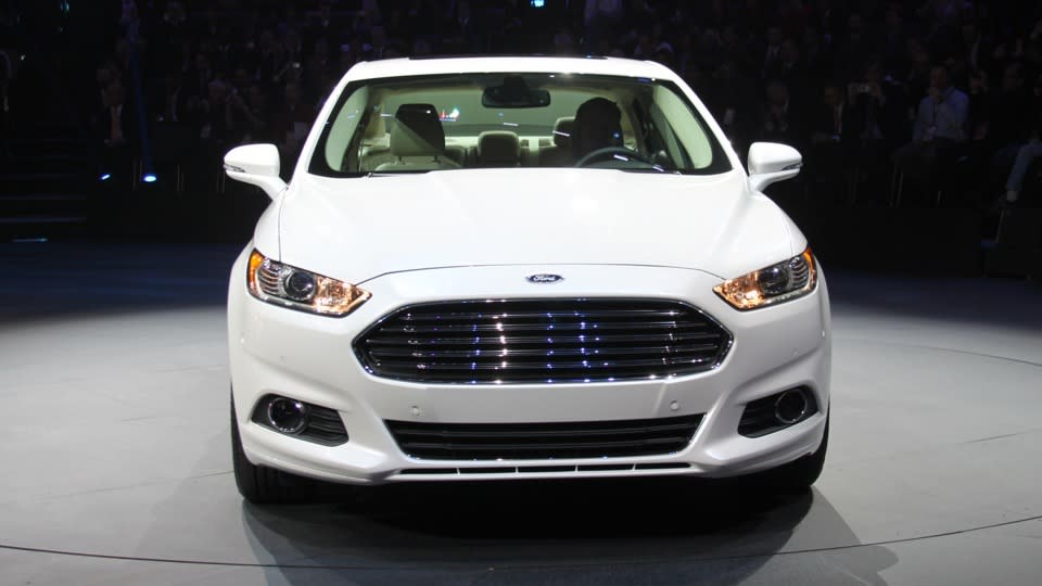 Later this year, Ford Motor Co. will launch this: the 2013 Ford Fusion midsize sedan in three variations — including a plug-in hybrid that gets 100 mpg, besting every other liquid-powered vehicle for sale to the American public. It could be a winning equation, but there's a few key variables Ford hasn't revealed. The current Fusion has turned into a mainstay of Ford's lineup, and the most popular car built by an American automaker, with sales hitting 248,067 in 2011. For its redesign, Ford will run the same play it's called on with the smaller Fiesta and Focus −- build one version of the Fusion for sale worldwide, using the Mondeo name in Europe and elsewhere, to lower costs while raising quality. Assembled in Mexico and Michigan, styled in Europe to follow the new Ford global look, two of its three engines will be built in Spain and England.