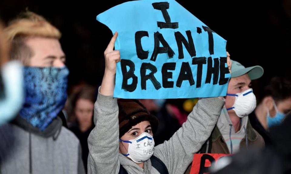 Protesters shout slogans and hold up placards during a rally in Sydney on Tuesday against the deaths of members of the Aboriginal community in Australia and of George Floyd in the US.