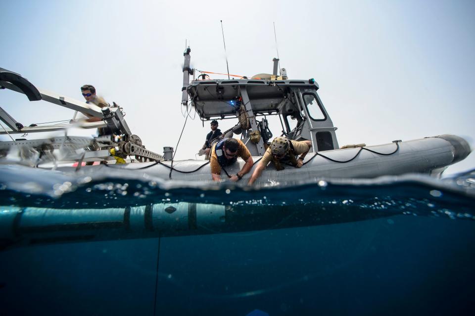 U.S. Navy sailors launch an unmanned underwater vehicle (UUV) from a 35-foot rigid-hull inflatable boat.