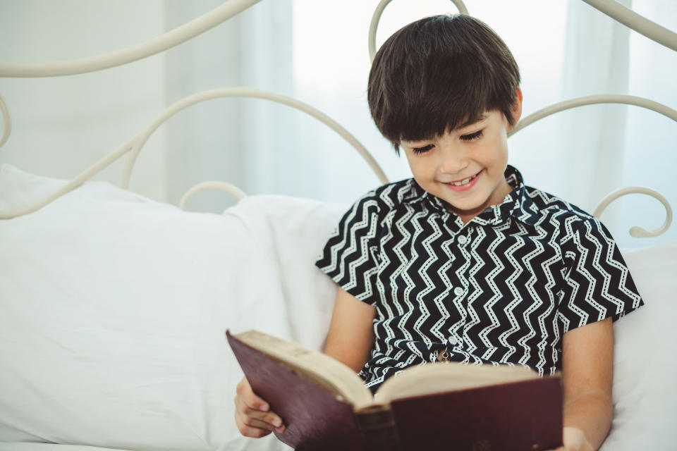 Boy reading book with smile and happy.
