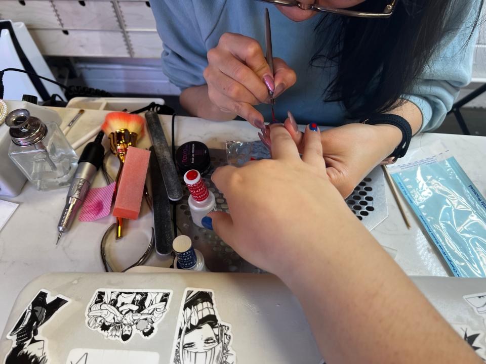 nail artist doing a japanese gel manicure on a customer