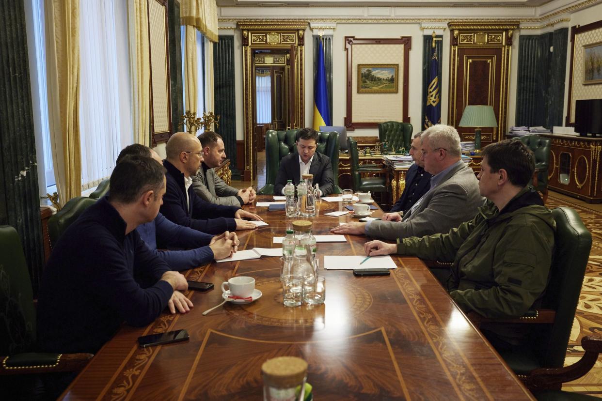 In this handout photo provided by the Ukrainian Presidential Press Office, Ukrainian President Volodymyr Zelenskyy, center, attends an urgent meeting with the leadership of the government, representatives of the defense sector and the economic block in Kyiv, Ukraine, Thursday, Feb. 24, 2022. Russian troops have launched their anticipated attack on Ukraine.