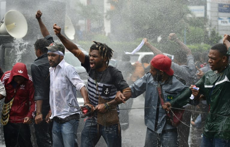 Protesters confront police using water cannons during a protest by mostly university students from the Free Papua Organization and the Papua Student Alliance in Jakarta