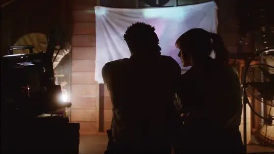 a man and woman standing in front of a drum set