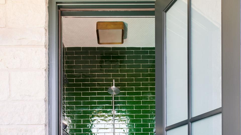 walk in bathroom with green shower tile