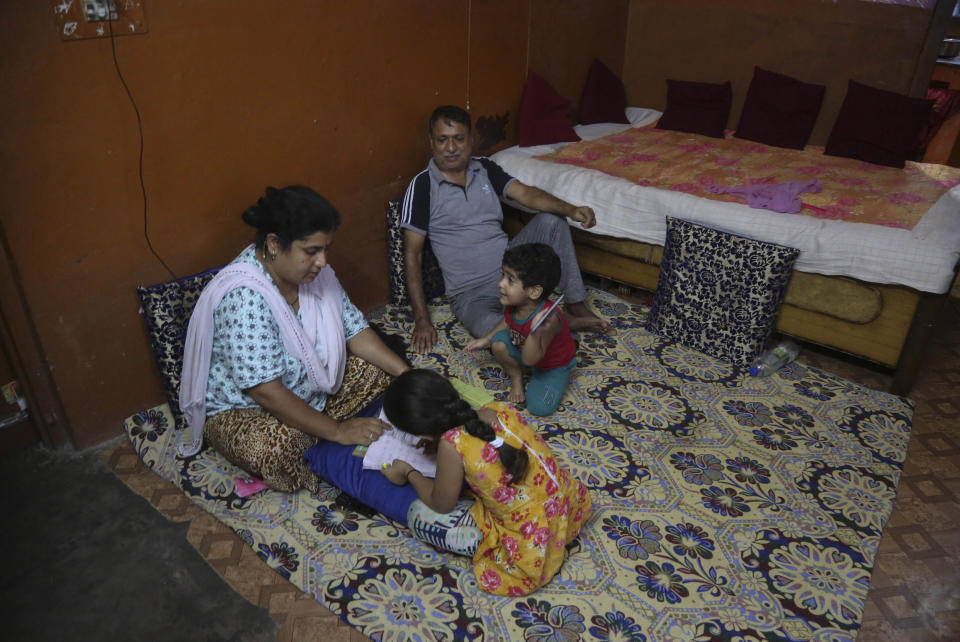 In this Aug. 29, 2019, photo, a Kashmiri Hindu family spends an evening inside their residence at Muthi migrant camp in Jammu, India. Tens of thousands of Kashmiri Hindus fled the restive region nearly 30 years ago, and the ghost of insurgency and their mass exodus still haunts them. They celebrated after India’s Hindu nationalist-led government stripped political autonomy from its part of Muslim-majority Kashmir on Aug. 5. Kashmiri Hindus view it as a step toward justice and possible return to their homeland. But many are still wary of returning. (AP Photo/Channi Anand)