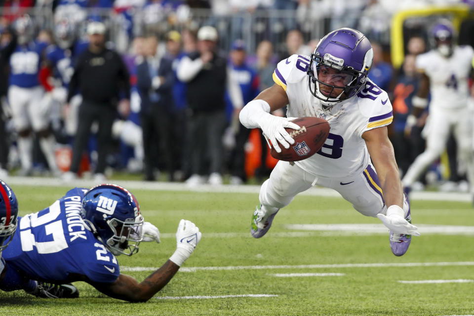 Minnesota Vikings wide receiver Justin Jefferson (18) catches a 17-yard touchdown pass ahead New York Giants cornerback Jason Pinnock (27) during the second half of an NFL football game, Saturday, Dec. 24, 2022, in Minneapolis. (AP Photo/Bruce Kluckhohn)