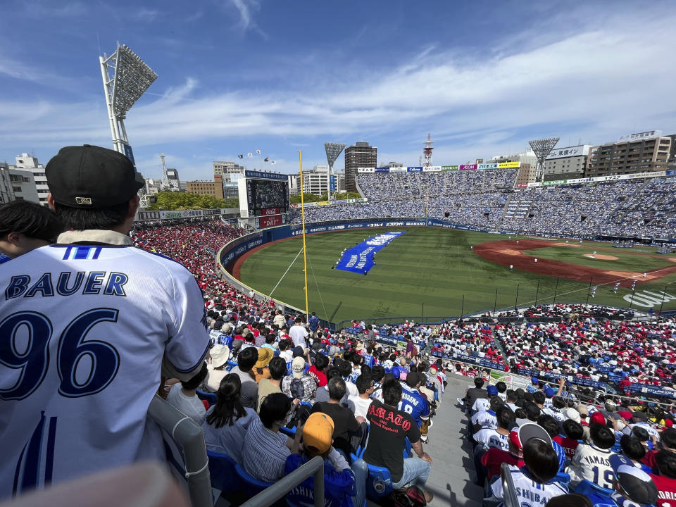 Audience members including fans wearing shirts with the name of Yokohama DeNA BayStars starting pitcher Trevor Bauer during their game against the Hiroshima Toyo Carp in Yokohama, south of Tokyo, Wednesday, May 3, 2023. (AP Photo/Stephen Wade)