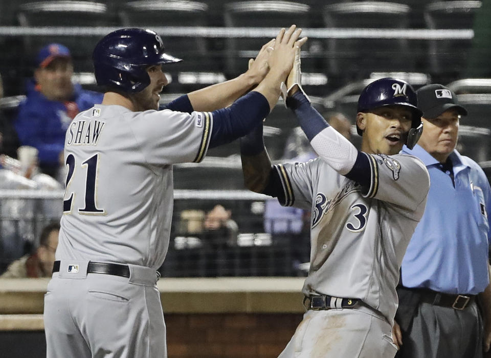 Milwaukee Brewers' Travis Shaw (21) celebrates with Orlando Arcia (3) after they scored on a three-run double by Lorenzo Cain during the fifth inning of a baseball game against the New York Mets Friday, April 26, 2019, in New York. (AP Photo/Frank Franklin II)