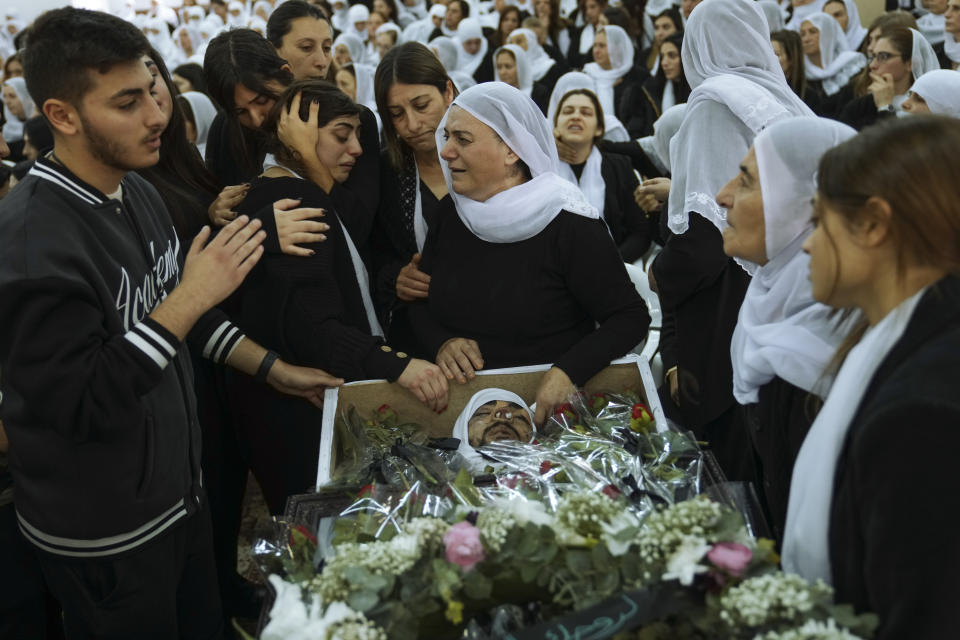 Members of the Israeli Druze minority mourn around the body of Tiran Fero, 17, during his funeral in Daliyat al-Carmel, Israel, Thursday, Nov. 24, 2022. Fero's body, which was taken by Palestinian militants from a West Bank hospital where he was seeking treatment after a car accident, was returned to his family on Thursday. (AP Photo/Mahmoud Illean)