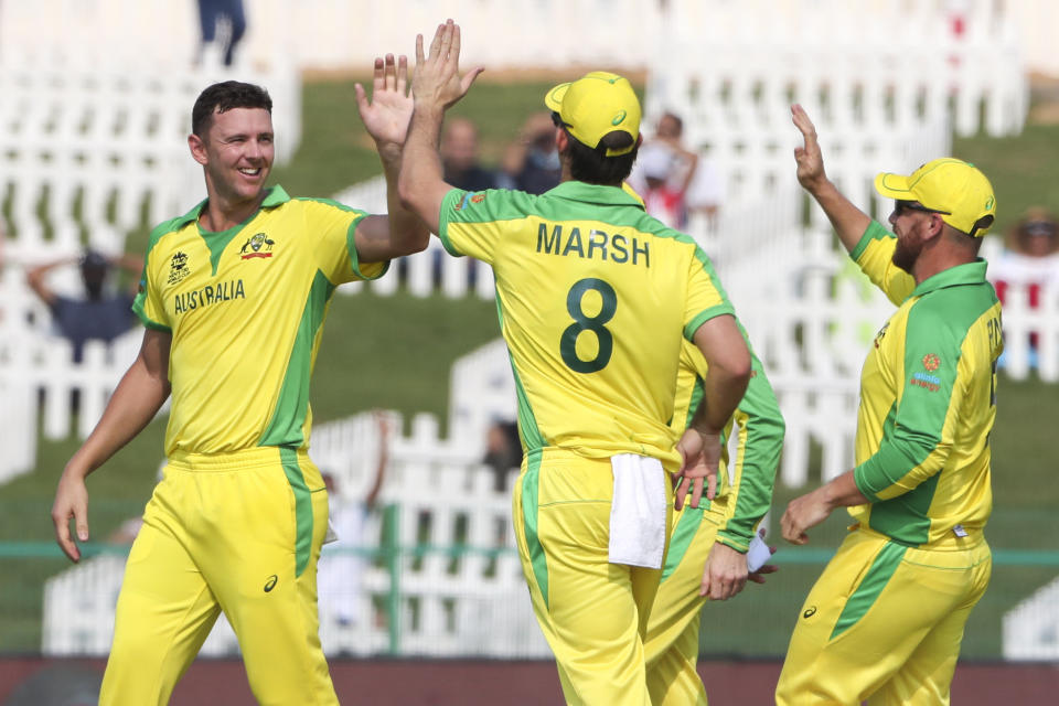 Australia's Josh Hazlewood, left, is congratulated by teammate's Mitchell Marsh, and Aaron Finch, right, after dismissing South Africa's Quinton de Kock during the Cricket Twenty20 World Cup match between South Africa and Australia in Abu Dhabi, UAE, Saturday, Oct. 23, 2021. (AP Photo/Kamran Jebreili)