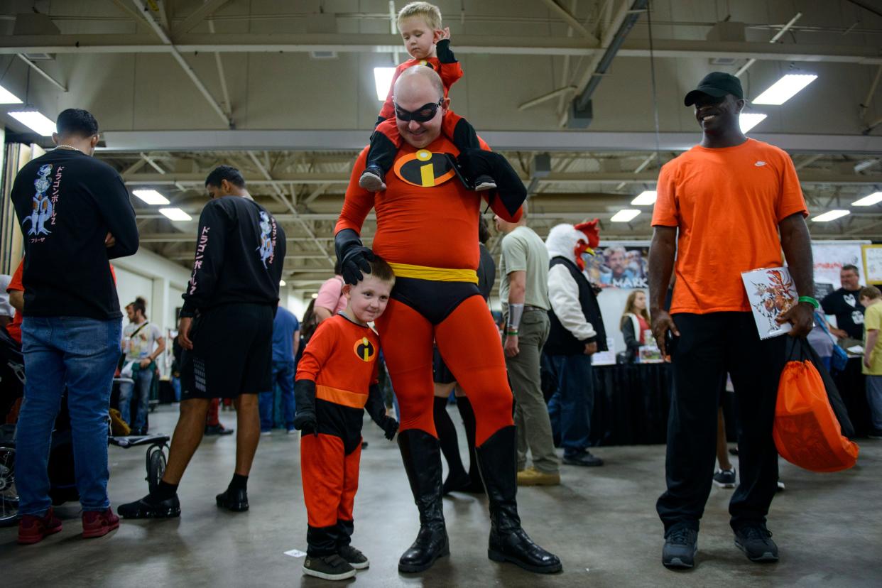 Danny Cooper walks through the Crown Coliseum with sons Baxter, 3, by his side and Barrett, 1, on his shoulders dressed as Incredibles character at the 2018 Comic-Con.