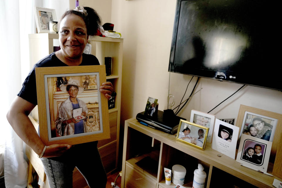 Jennifer Jones proudly shows a picture of her mother in her small flat in London, Thursday, Aug. 25, 2022. Like millions of people, Jones, 54, is struggling to cope as energy and food prices skyrocket during Britain's worst cost-of-living crisis in a generation. The former school supervisor has health problems and relies on government benefits to get by, but her welfare payments are nowhere near enough to cover her sharply rising bills. (AP Photo/Frank Augstein)