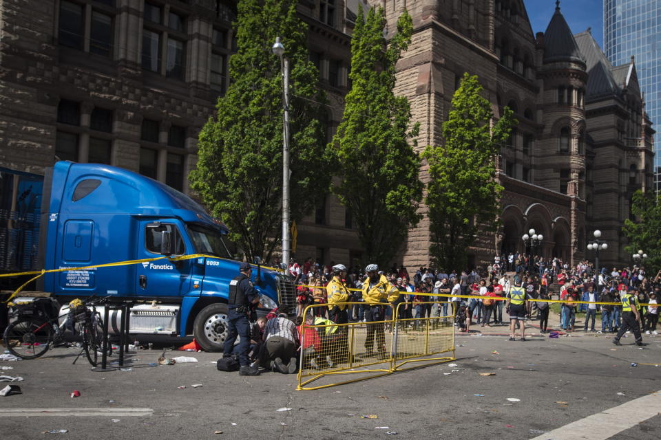 First responders help treat an injured person after a shooting in Toronto during the Raptors victory parade..