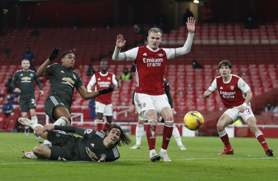 Manchester United's Edinson Cavani (on the ground) and Anthony Martial in action with Arsenal's Rob Holding. 