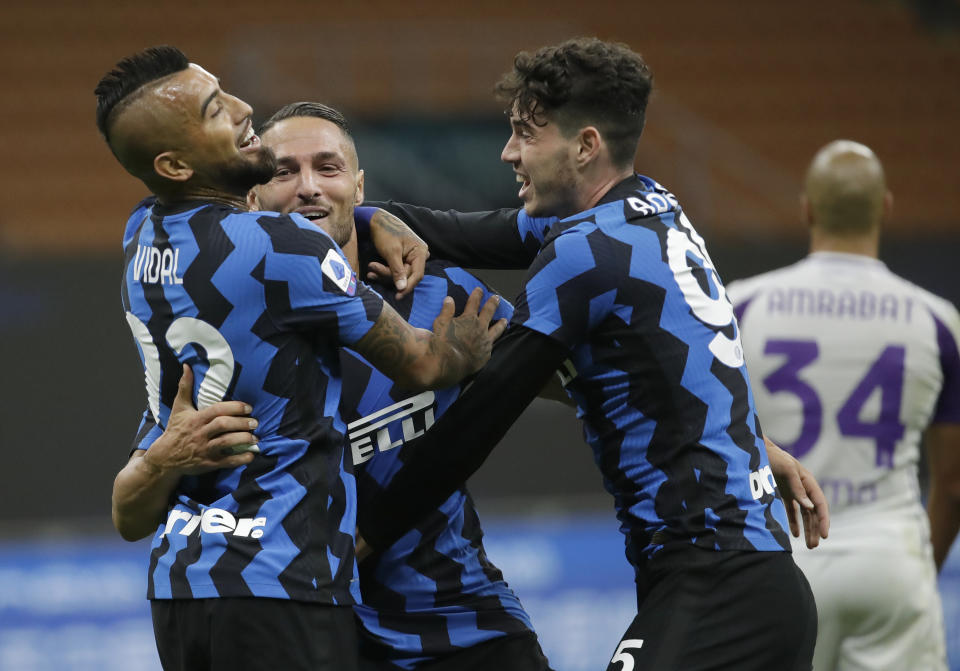 Danilo D'Ambrosio (centro) festeja con sus compañeros Arturo Vidal (izquierda) y Alessandro Bastoni tras conseguir el cuarto gol del Inter ante la Fiorentina, el sábado 26 de septiembre de 2020, en Milán (AP Foto/Luca Bruno)