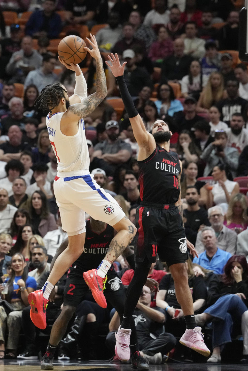 LA Clippers guard Amir Coffey (7) aims a three point basket as Miami Heat forward Caleb Martin (16) defends during the first half of an NBA basketball game, Sunday, Feb. 4, 2024, in Miami. (AP Photo/Marta Lavandier)