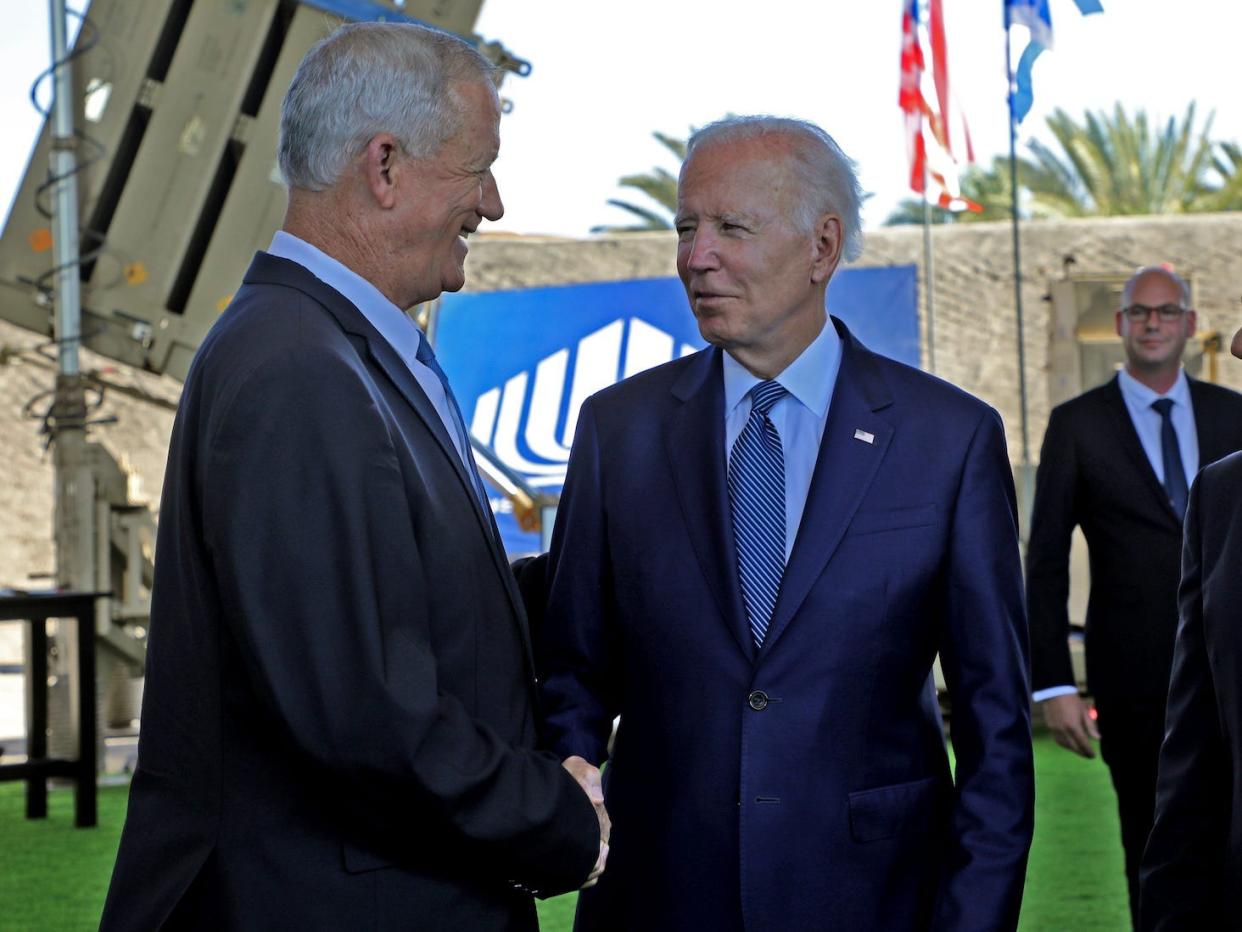 President Joe Biden shakes hands with Israeli Defence Minister Benny Gantz as they stand in front of Israel's Iron Dome defence system during a tour at Ben Gurion Airport near Tel Aviv on July 13, 2022.