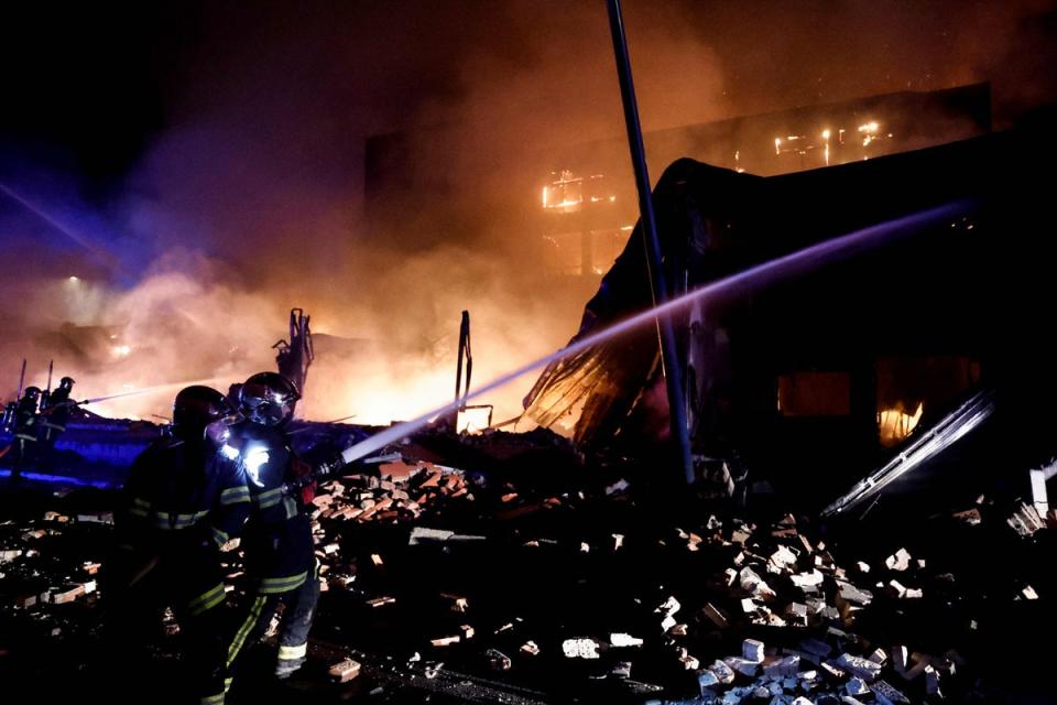 Firefighters douse the flames of a hotel set on fire during protests in Roubaix, northern France (AFP via Getty)