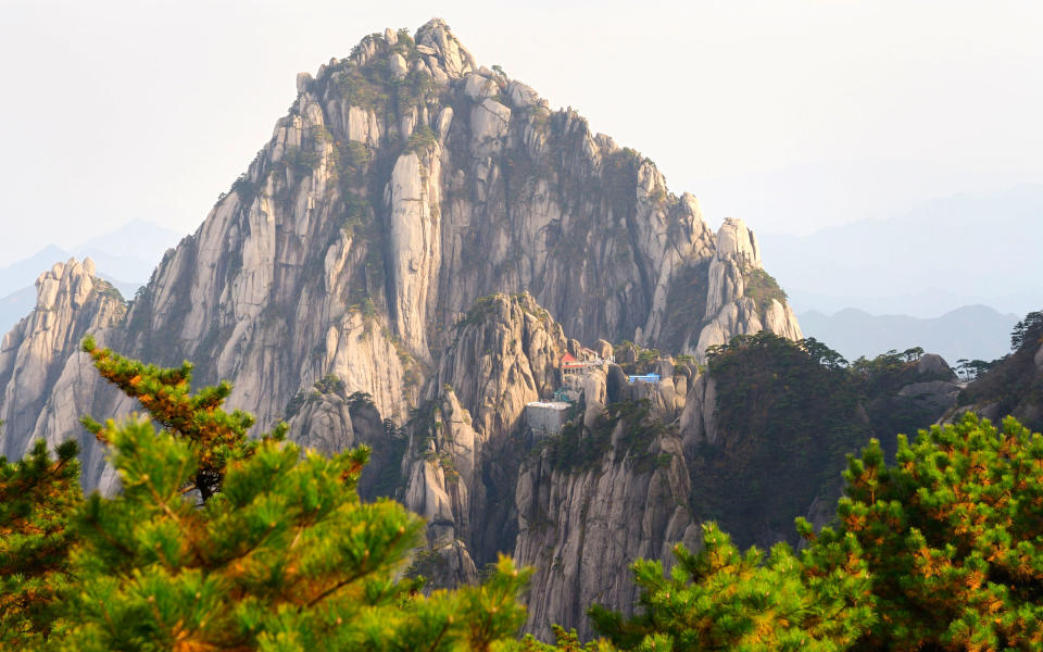 <p>To check into the hotel that sits atop China’s Yuping Mountain, you'll need to embark on a five-hour drive or equally long bullet train ride from Shanghai to Huangshan, or take an hour-long flight. From there, it's an additional 56-mile drive toward the looming mountain range and a two-hour climb up Yuping Mountain. The 60,000 stone steps that lead to the summit wind through sheer cliffs and low-lying clouds that shade the narrow mountain pass known as the Thread of Sky. Jade Screen Hotel can also be reached by cable car. This modest property cuts a dramatic silhouette over the landscape. Surrounded by thousand-year-old pine trees, Jade Screen offers sweeping views of the valley below and has on-site sauna and massage facilities for restoring aching muscles before you make the trip back down. </p>