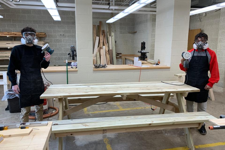 Sebring carpentry students prepare to sand a picnic table commissioned for Canaan Acres.