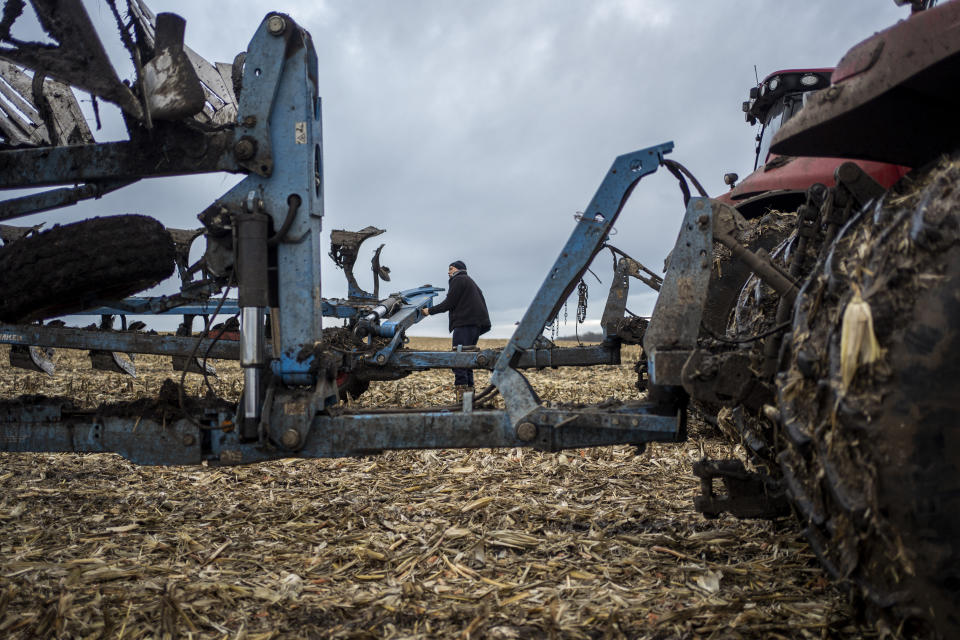 A farmer operates a tractor at a cornfield in Sumy region, Ukraine, on Friday, Nov. 24, 2023. A local agricultural company operating just a few kilometers from the border with Russia continues to grow grains despite facing dangers of shelling and mines. (AP Photo/Hanna Arhirova)