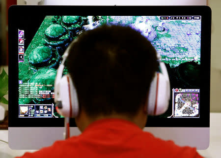 FILE PHOTO: A man plays a computer game at an internet cafe in Beijing,China May 9, 2014. REUTERS/Kim Kyung-Hoon/File Photo