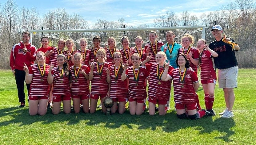 Monroe's girls soccer team celebrates its victory in the Kestrel Invitational Saturday. The Trojans beat host St. Mary Catholic Central 6-0 in the finals.