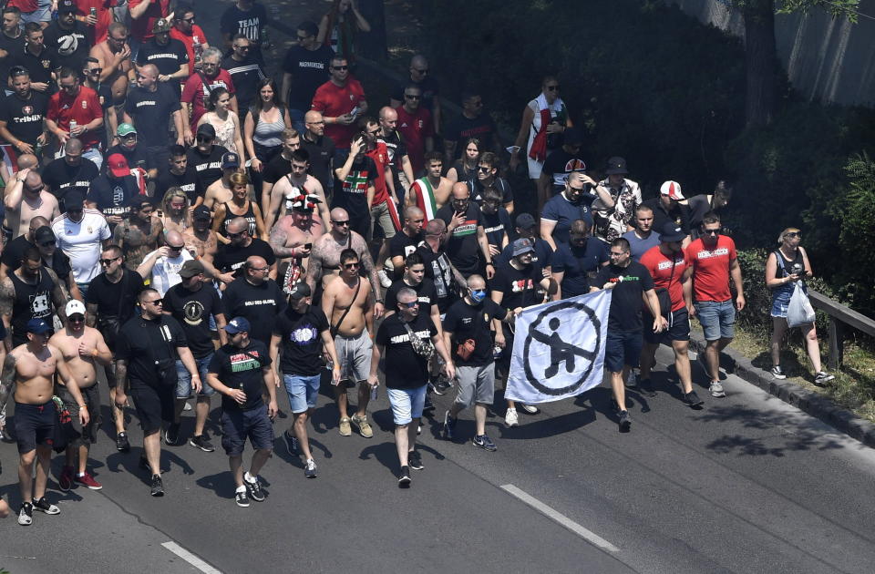 FILE - Hungarian fans, carrying a banner opposed to players taking the knee, march towards the Puskas Arena in Budapest, Hungary just hours before Hungary will face France in their Euro 2020 group F preliminary round soccer match on Saturday, June 19, 2021. (Zoltan Mathe/MTI via AP, File)