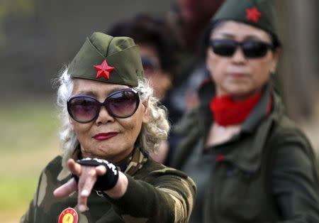 Seventy-nine-year-old Wang Baorong, dressed in military style clothes, performs square dancing at a park square in Beijing, China, April 9, 2015. REUTERS/Kim Kyung-Hoon