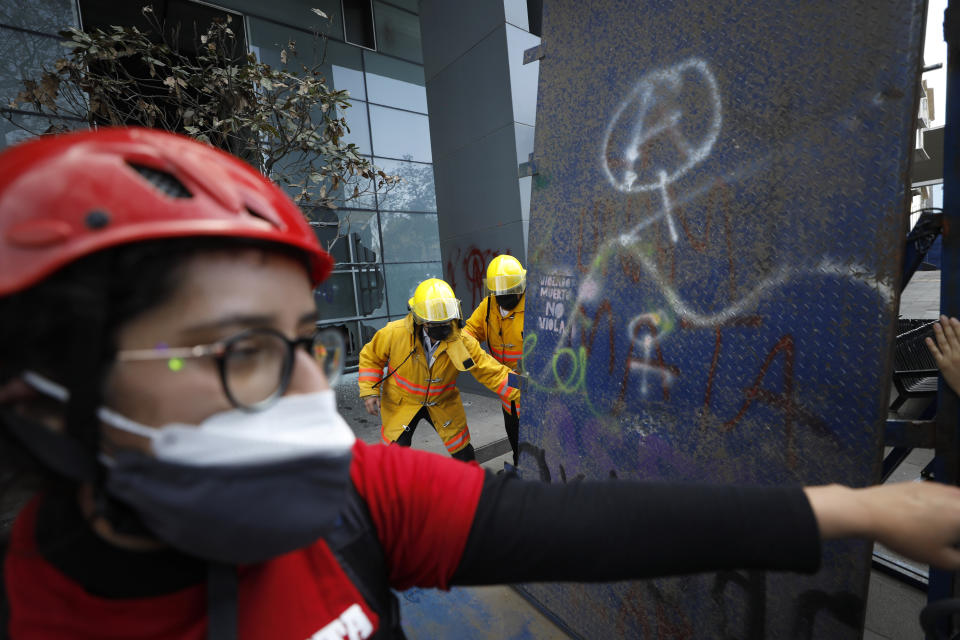 Paramedics leave the area after women demonstrators are allowed to leave the scene after they broke through a barricade and smashed the lobby of the Mexico City Hilton hotel during a march to commemorate International Women's Day and protesting against gender violence, Monday, March 8, 2021. (AP Photo/Rebecca Blackwell)