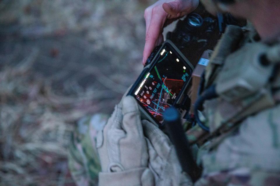 A soldier from the 101st Airborne Division checks his Nett Warrior end user device during a full mission test at Aberdeen Proving Ground, Maryland, in February 2021. (Justin Sweet/Army)