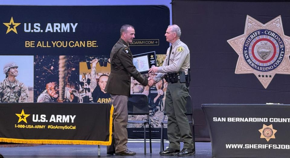 U.S. Army Lt. Col. Matthew Upperman, left, and San Bernardino County Sheriff Shannon Dicus, right, sign a memorandum of understanding bringing the sheriff's department into an Army program meant to fast-track soldiers into law enforcement careers after military service.