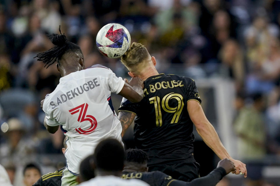 Vancouver Whitecaps defender Sam Adekugbe, left, heads the ball past Los Angeles FC midfielder Mateusz Bogusz to score during the first half of an MLS playoff soccer match Saturday, Oct. 28, 2023, in Los Angeles. (AP Photo/Ryan Sun)